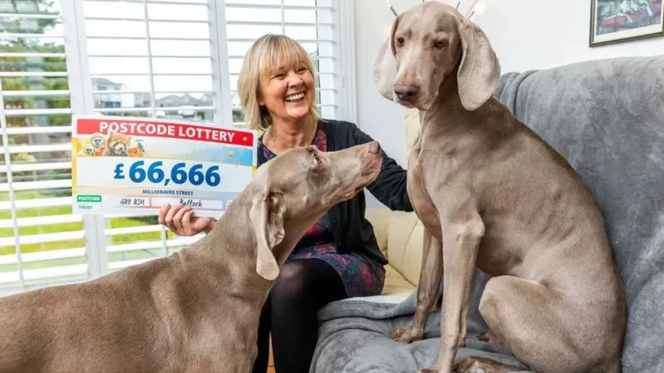Эйлин Саттер с победным чеком на 66 666 фунтов стерлингов и своими собаками