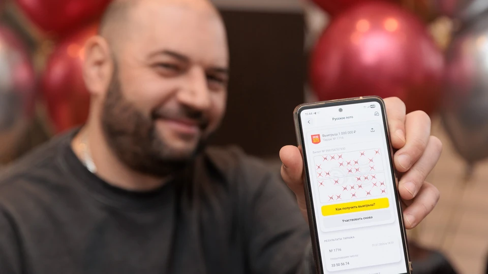 Победитель лотереи от «Столото» Михаил М. показывает на экране смартфона выигрышный билет «Русского лото» на 1 000 000 рублей в 1716-м тираже