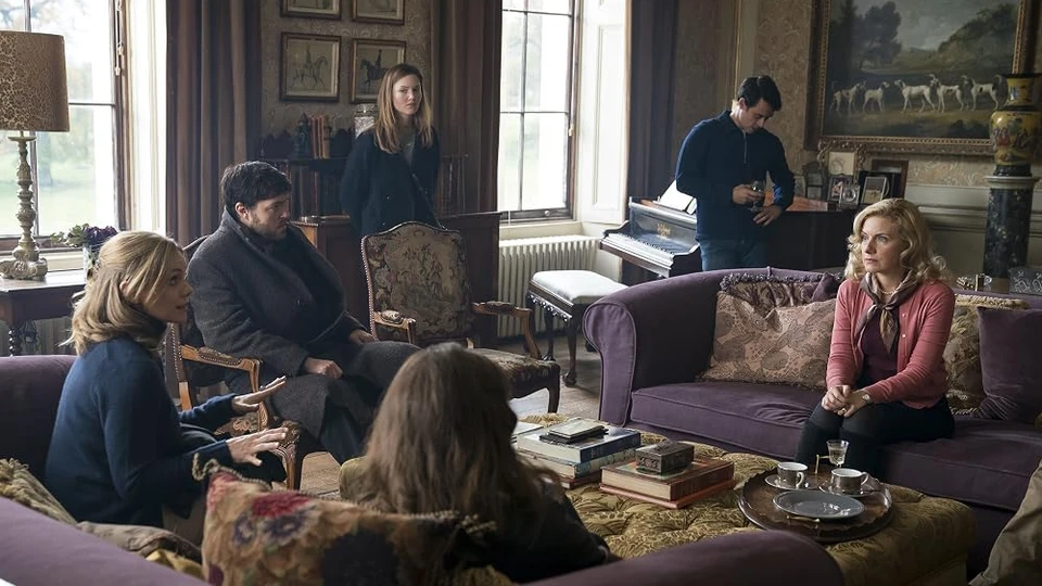 Страйк и Робин в гостиной загородного дома, кадр из сериала «Страйк»
