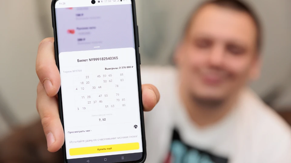Сергей показывает свой выигрыш в приложении «Столото»