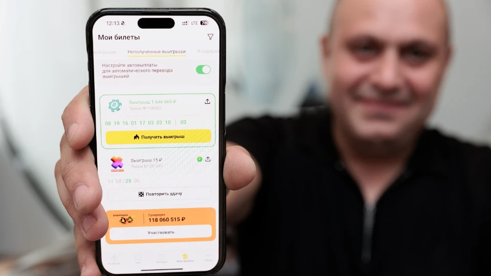 Победитель Назим показывает свой выигрыш в приложении «Столото»