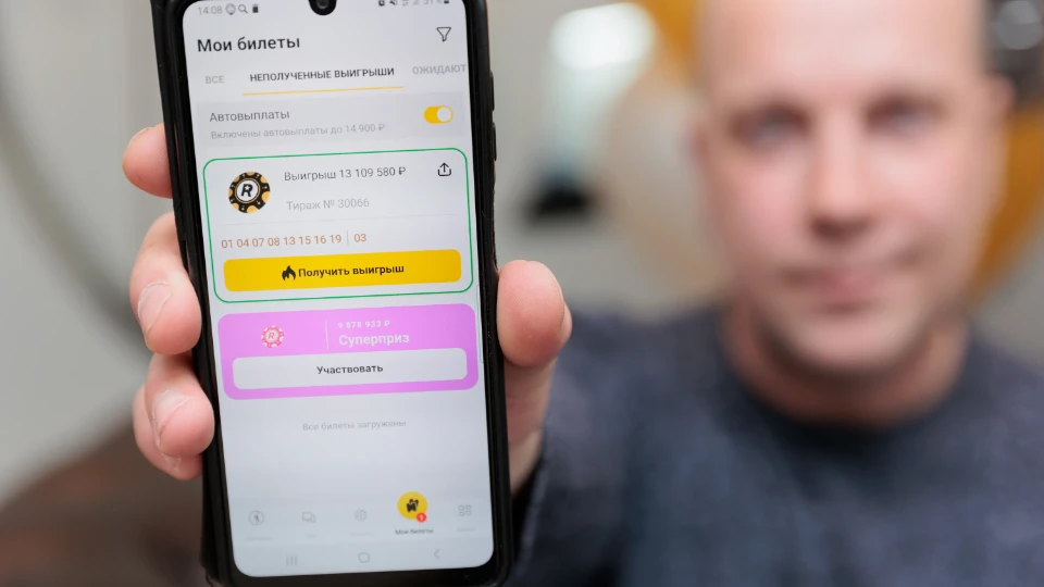 Победитель показывает выигрыш в 13 млн на своем смартфоне