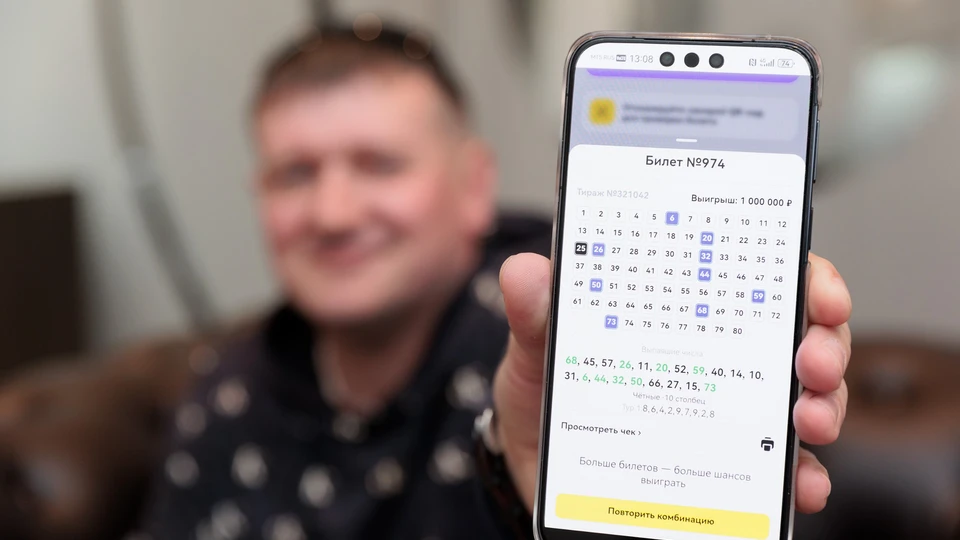 Победитель показывает на смартфоне выигрышный билет «КЕНО» с выигрышем 1 000 000 рублей